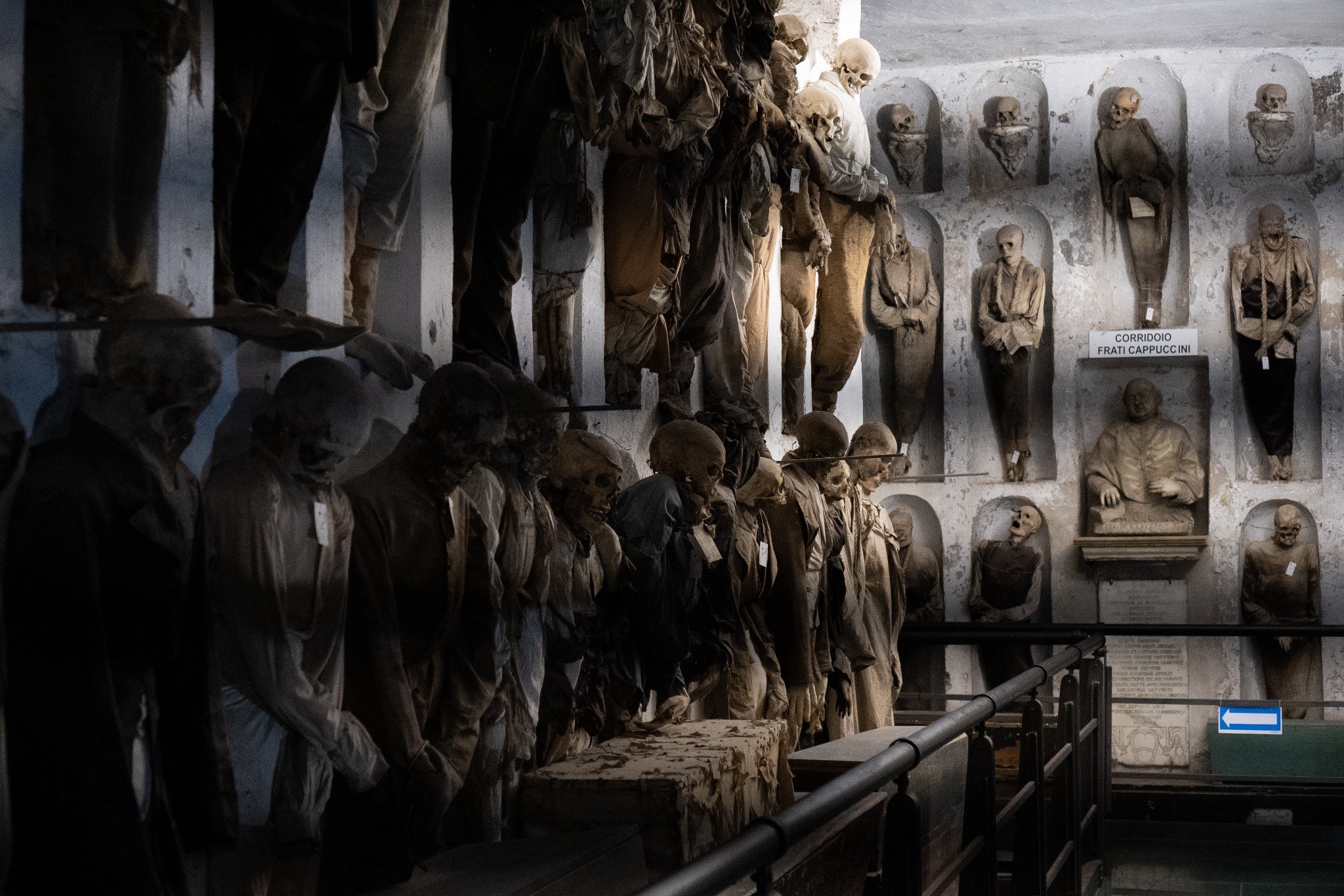 Catacomb room with preserved bodies and skulls arranged along the walls