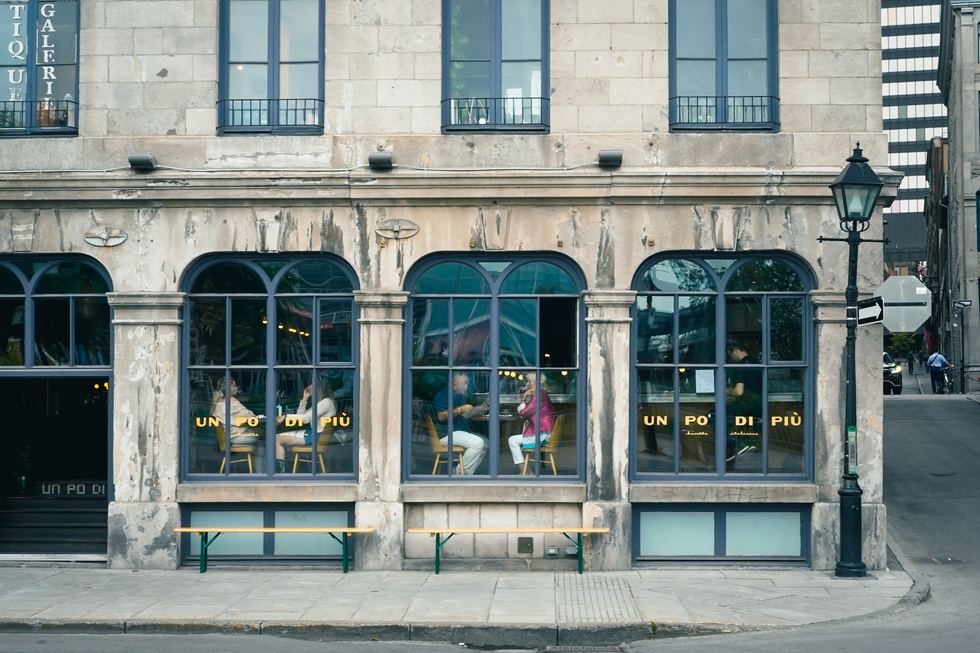 People seated inside a café seen through large street windows